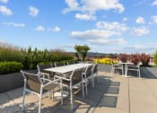 Thumbnail 10 of 21 - a patio with tables and chairs on the roof of a building
