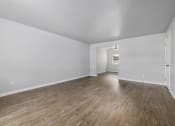 Thumbnail 3 of 8 - North River Apartments living room and dining room of an empty house with wood floors