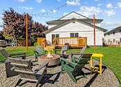 Thumbnail 25 of 26 - A fire pit surrounded by chairs in a backyard.