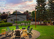 Thumbnail 26 of 26 - A backyard with a fire pit and chairs.