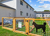Thumbnail 24 of 26 - A dog park sign is on a fence in front of a grassy area.