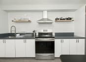Thumbnail 3 of 33 - a kitchen with white cabinets and a black counter top