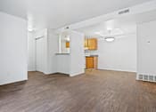 Thumbnail 8 of 10 - A room with wooden floors and white walls.