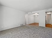 Thumbnail 7 of 10 - A spacious room with a grey carpet and white walls.