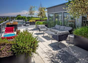 Thumbnail 19 of 35 - A patio with a red chair and a grey sofa.