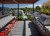 Thumbnail 17 of 35 - A patio with red chairs and a grill.
