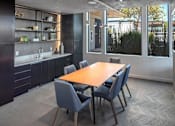 Thumbnail 26 of 35 - A modern kitchen with a dining table and chairs.