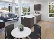 Thumbnail 12 of 35 - A modern kitchen with a table and chairs in the foreground.