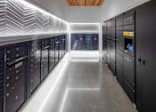 Thumbnail 9 of 35 - A long hallway with a series of lockers on the side and a light strip on the ceiling.