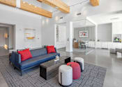 Thumbnail 29 of 35 - A modern living room with a blue couch and red pillows.