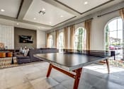 Thumbnail 3 of 28 - A modern dining room with a glass table and a television mounted on the wall.