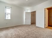 Thumbnail 11 of 21 - A room with a carpeted floor, a window, and a door.