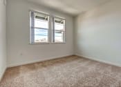Thumbnail 18 of 28 - A room with two windows and carpeted floor.