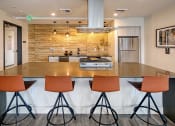 Thumbnail 36 of 48 - a kitchen with a large counter with four chairs