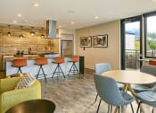 Thumbnail 27 of 48 - a community room with a kitchen and a table with chairs