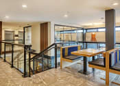 Thumbnail 25 of 48 - a seating area with tables and chairs in a lobby with a staircase