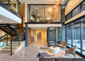 Thumbnail 34 of 48 - a living room with glass doors and a staircase and a table and chairs