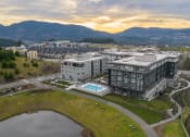 Thumbnail 46 of 48 - an aerial view of a building with a pool and mountains in the background