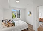 Thumbnail 4 of 30 - A bedroom with a large bed and a window overlooking a green area.