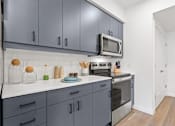 Thumbnail 2 of 30 - A kitchen with grey cabinets and a white countertop.