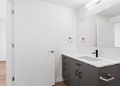 Thumbnail 11 of 30 - A bathroom with a sink, mirror, and cabinets.