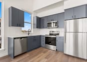 Thumbnail 10 of 30 - A kitchen with stainless steel appliances and wooden floors.