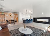 Thumbnail 16 of 30 - A modern living room with a fireplace and a dining table.