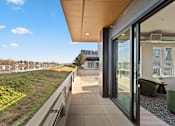 Thumbnail 20 of 30 - A modern building with a balcony overlooking a river.