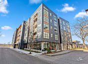 Thumbnail 28 of 30 - A modern multi-story building with a mix of dark and light colored windows.