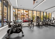 Thumbnail 25 of 30 - A gym with a row of treadmills and stationary bikes.