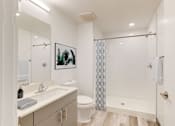 Thumbnail 9 of 32 - A white bathroom with a toilet, sink, and shower.