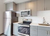 Thumbnail 5 of 32 - A modern kitchen with a stainless steel refrigerator, microwave, and dishwasher.