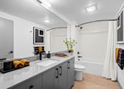 Thumbnail 9 of 32 - A bathroom with a white sink and a white toilet.