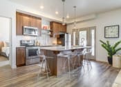 Thumbnail 26 of 35 - a kitchen with a large island with three stools