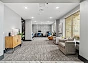 Thumbnail 11 of 33 - A modern office space with a grey carpet and a variety of seating options.