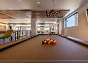 Thumbnail 12 of 28 - a pool table in the lobby of a building with balls on it