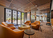 Thumbnail 10 of 28 - a lounge area with orange chairs and a glass table