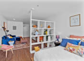 Thumbnail 1 of 5 - a bedroom with a bed and a living room with a couch and a chair