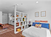 Thumbnail 2 of 5 - a bedroom with white walls and a white bed with blue and orange pillows