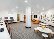 Thumbnail 6 of 34 - A room with a white table, chairs, and a mural of trees on the wall.