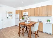 Thumbnail 9 of 34 - A kitchen with a table and chairs in the middle of the room.
