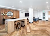 Thumbnail 2 of 34 - A kitchen with a bar area and a mirror on the wall.