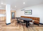 Thumbnail 4 of 34 - A modern dining room with a brown leather sofa and a black table.