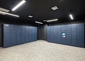 Thumbnail 27 of 34 - A storage room with blue lockers and a digital keypad on the right.