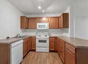 Thumbnail 5 of 13 - A kitchen with wooden cabinets and white appliances.