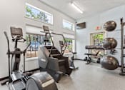Thumbnail 4 of 30 - Fitness center with machines and weights at Cedar Crest Apartments in West Beaverton, Oregon.
