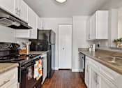Thumbnail 8 of 30 - A kitchen with black appliances and white cabinets.