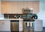 Thumbnail 2 of 7 - A modern kitchen with a stainless steel dishwasher and oven.