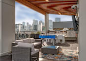 Thumbnail 5 of 7 - A patio with a table and chairs and a view of the city.
