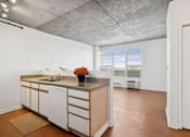 Thumbnail 18 of 20 - A kitchen with white cabinets and a wooden island.